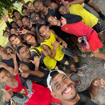 Victor em selfie com uma equipe de futebol após trabalho em campo