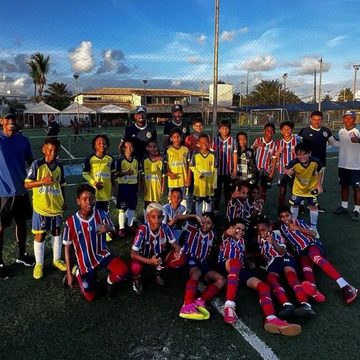 Victor com atletas de base em um campo de futebol